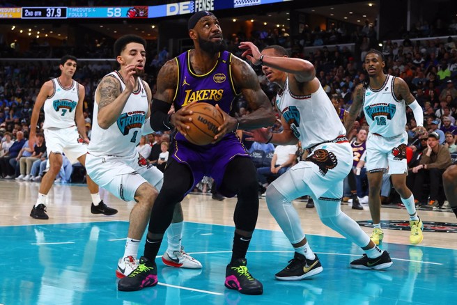 就算在禁区碰到两名灰熊球员包夹，詹姆斯(中)仍然想要强行起身出手。(路透)