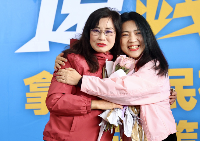 日前国民党台北市议员秦慧珠（左）上政论节目时，广告时间的閒聊遭放送出去，谈到遭罢免的国民党立委徐巧芯愈走愈极端。国民党立委徐巧芯（右）30日在「还钱于民政策说明会」中，送上玫瑰花给秦慧珠，两人并相互拥抱。（邓博仁摄）