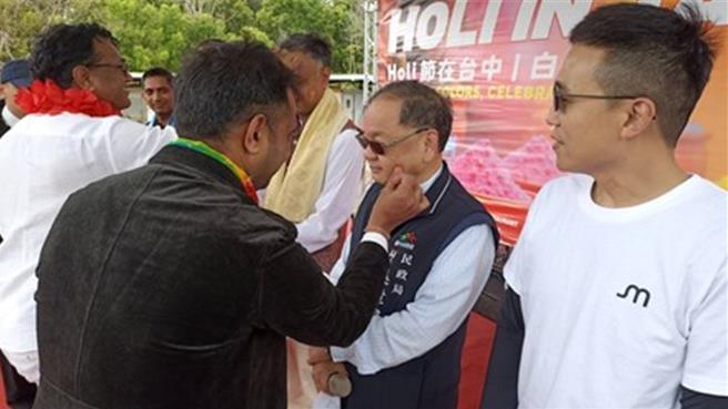 外國友人將彩色顏料塗抹在民政局長吳世瑋臉上，象徵祝福與愛。（台中市府提供）