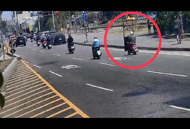 一名机车骑士竟将近2米高的巨大门框直接立在脚踏垫上，摇摇晃晃骑上路。（图警方提供／简铭柱翻摄）