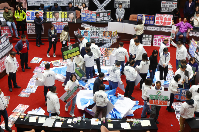 民进党立法院党团为阻挡3月25日院会议事录确认，1日发布甲级动员，下午蓝委持罢免民进党立委的看板，站在「罢」字呼口号叫阵，随后将民进党「罢」字大海报踢烂。民进党立委则在主席台上高喊「大罢免、大成宫」等口号。（邓博仁摄）
