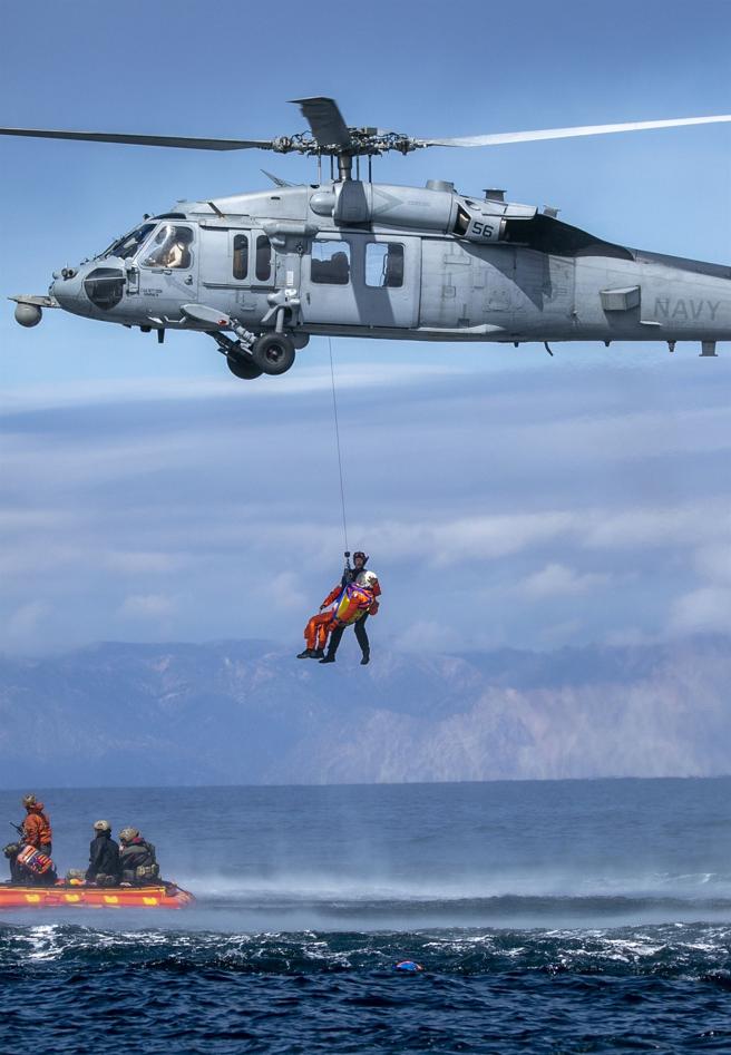 美海軍MH-60R吊掛太空人離開救生筏，準備返回「桑默塞特號」。（取自DVIDS網站）