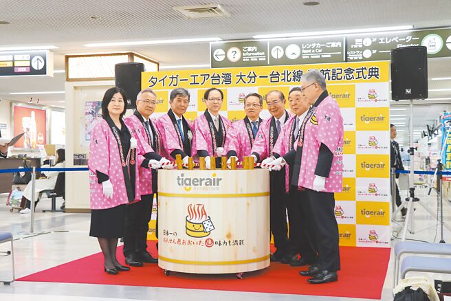 台湾虎航2日首航日本大分县，虎航与大分县官员在大分机场进行传统镜开仪式，特别用当地着名的温泉桶取代酒桶表达敬贺。（蔡明亘摄）