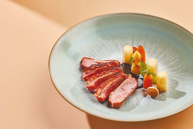 主厨将乾煎脆皮樱桃鸭胸搭配法国白芦笋，皮脆肉嫩的鸭肉，与清爽的白芦笋相得益彰。（诚品行旅提供）