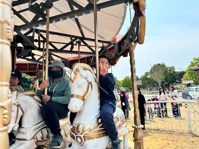參與的身心障礙兒童坐上旋轉木馬，展露開心笑容。（台南市社會局提供／郭良傑台南傳真）
