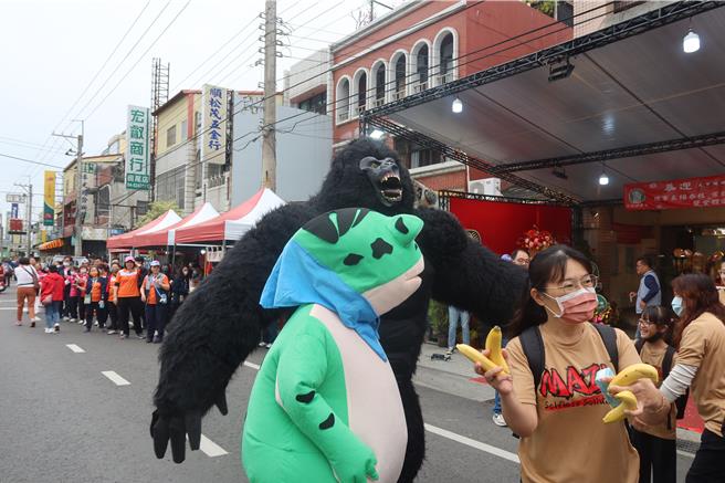 有业者出动黑金刚及蛙人，在田尾乡农会分部前迎接大甲妈及香客，让途经的香客纷纷停下脚步，抢着与他们合影留念。（叶静美摄）