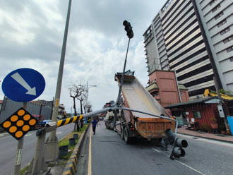 八里砂石車車斗忘放下　2號誌桿無辜遭殃