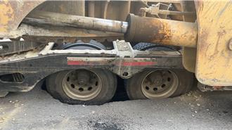 下滑的不只股市！高雄拖板车载怪手突陷坑洞无法动弹