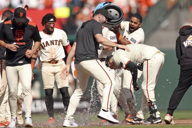 巨人代打佛罗瑞斯(右)被队友淋水桶庆祝再见安打。（美联社）