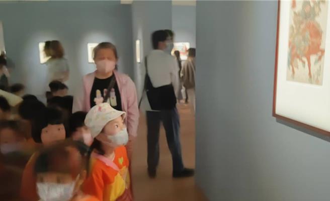 在展览现场，孩子们睁大眼睛，兴奋地讨论画作中的人物及风景。（林雅惠摄）