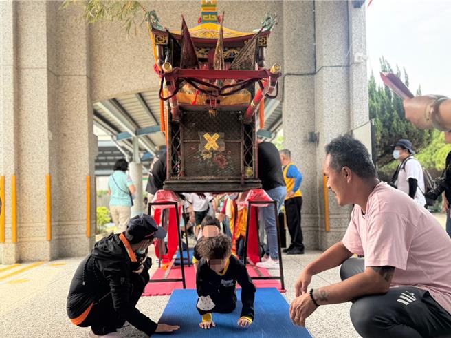 台中市大里区心振坤宫8日也进行巡庄赐福游街，涂城国小结合地方文化推动特色课程，带领四年级孩子体验「钻轿脚」活动，让学生了解地方信仰文化。（潘虹恩摄）