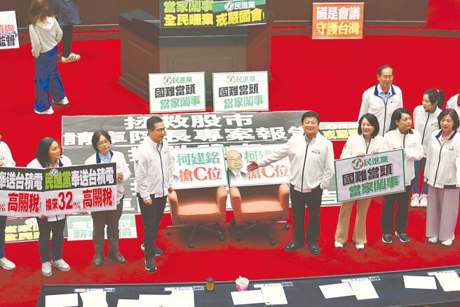 針對民進黨立委占領主席台並杯葛議事，國民黨立委拿出標語抗議民進黨「國難當頭，當家鬧事」。（姚志平攝）