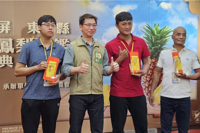 屏东县政府举办优质金钻凤梨评鑑，前3名分别为蓝天合作社潘琮咏（右二）、双丰合作社潘清立（右一）、潮州镇农会林舜英因为工作忙，由儿子陈信安（左一）代领，与屏东县副县长黄国荣（左二）合影。（罗琦文摄）