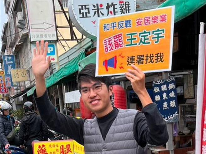 胡永融担任罢免王定宇的领衔人，在街头举牌请人支持连署罢免。（翻摄胡永融脸书／郭良杰台南传真）