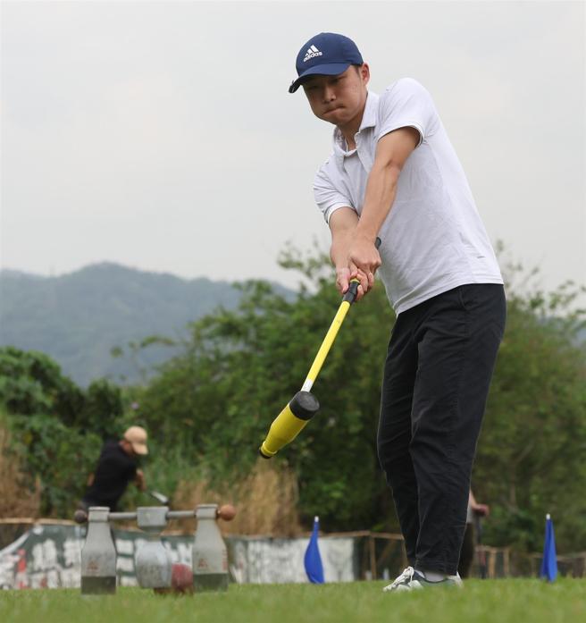 国防大学木球队选手屏气凝神，挥杆将木球推向球门。（记者黄迪明摄）