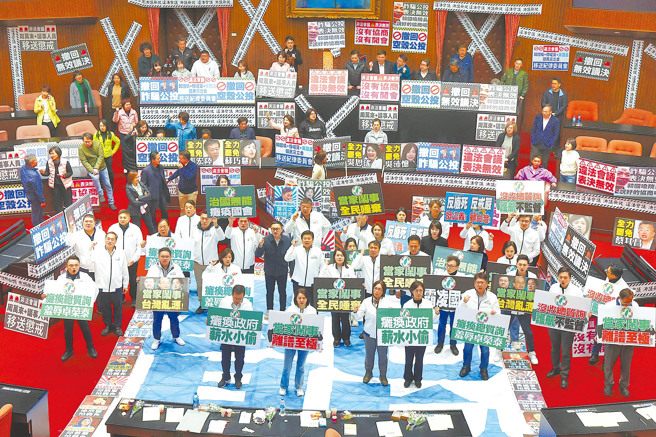 图为民进党立法院党团4月1日发布甲级动员，霸占主席台高喊「大罢免、大成功」口号，蓝委站在「罢」字上呼口号叫阵，随后将民进党「罢」字大海报踢烂。（资料照／邓博仁摄）