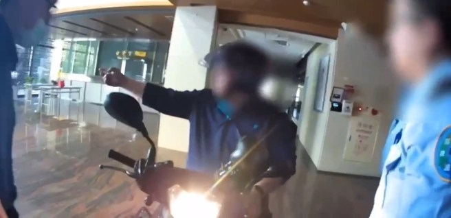 男子骑车衝进法务部内，遭警带回侦办。（翻摄画面）