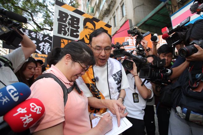 国民党主席朱立伦（中）17日赴板桥，与罢免民进党立委张宏陆的团体志工一起上街宣传，朱立伦更亲自协助民眾填写连署书。（黄世麒摄）