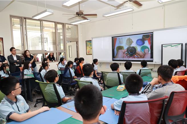 秀育企業捐贈南投縣國中小學共1744台實物投影機，學生在座位聽老師講解陶藝訣竅。（楊靜茹攝）
