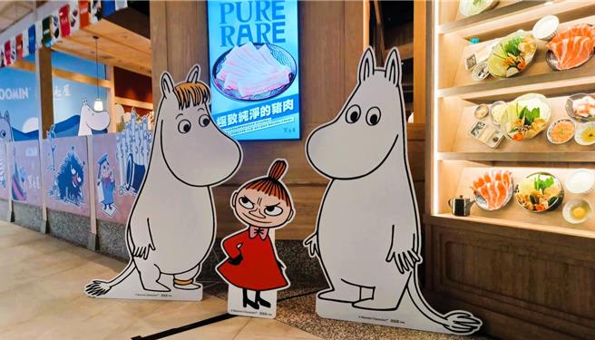 「黑毛屋X MOOMIN姆明主題鍋物店」隨處可見身形圓潤、有著大大的鼻子的可愛姆明，店外規劃主題背板，提供顧客與姆明角色互動拍照。（陳韻萍攝）