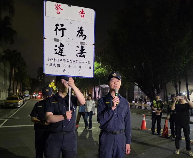 警方在晚间11点36分第一次举牌警告行为违法。（林郁平摄）
