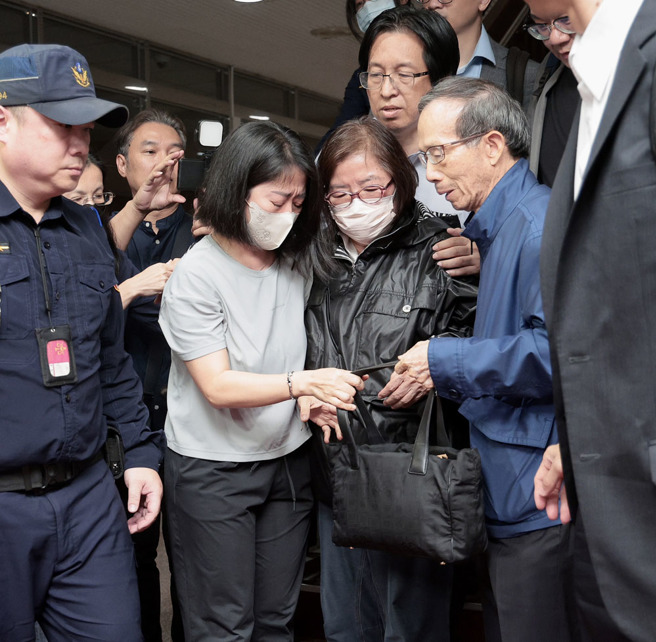台北地检署侦办国民党台北市党部连署涉偽造文书案，检察官18日清晨复讯后声押4人，台北地院19日凌晨5时裁定黄吕锦茹（中）、曾繁川无保请回，初文卿、姚富文 2人羁押禁见；黄吕丈夫黄秀庄（中右）在北院楼梯下焦急等待，黄吕下楼后与亲属相拥泣。（郭吉铨摄）
