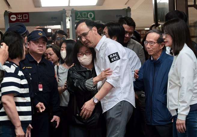 台北地检署侦办国民党台北市党部连署涉偽造文书案，检察官18日清晨复讯后声押4人，台北地院19日凌晨5时裁定黄吕锦茹（中）、曾繁川无保请回，初文卿、姚富文 2人羁押禁见；黄吕丈夫黄秀庄（中右）在北院楼梯下焦急等待，黄吕下楼后与亲属相拥泣。（郭吉铨摄）