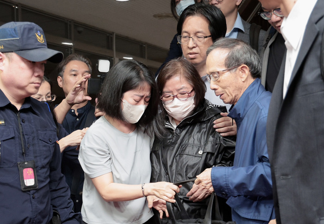 黃呂丈夫黃秀莊（中右）在北院樓梯下焦急等待，黃呂下樓後與親屬相擁泣。（郭吉銓攝）