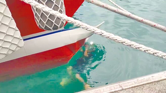 甫於上月啟用的新客輪「天王星21號」18日上午準備航出綠島南寮漁港時，右舷擦撞碼頭變形，基於安全考量，安排船上旅客改搭其他客輪。圖為潛水人員仔細檢查船體受損情形。（讀者提供／蔡旻妤台東傳真）