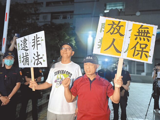 高雄雙罷劫負責人徐尚賢被移送至高雄地檢署問訊，複訊後遭聲押，徐父（右）與罷免許智傑領銜人朱磊（左）舉牌「非法逮人」、「無保放人」。（洪靖宜攝）