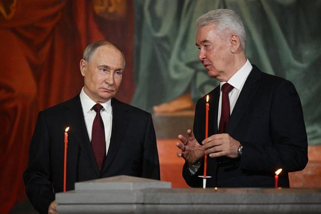  蒲亭（左）單方面宣布停火，但外界懷疑其意圖恐僅是「應付」美國施壓。圖為他出席復活節儀式。
（達志影像／路透社）