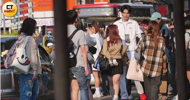 刚下工的王品澔，在粉丝包围下跟着工作人员准备一起搭车回伊林娱乐。（图／本刊摄影组）