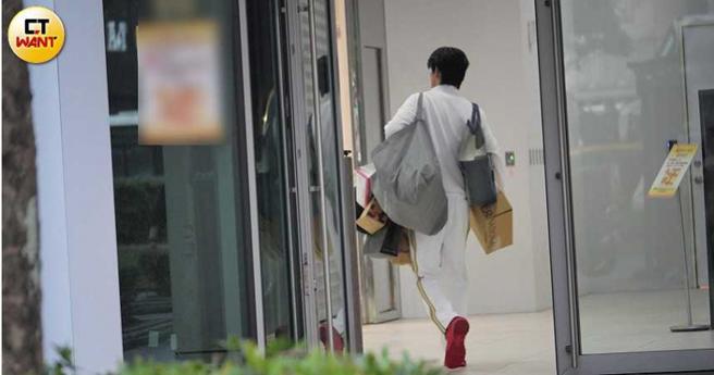 从公司离开的王品澔，两手上多了许多袋子。（图／本刊摄影组）