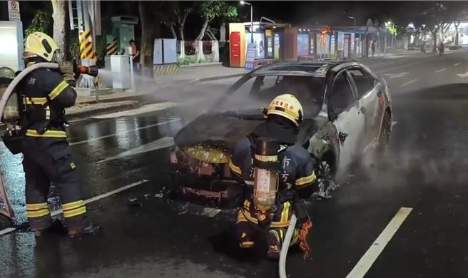 高雄市苓雅区三多一路靠近卫武营前路段，今（23）日一辆轿车银色轿车于晚间6点50分尖峰时段，引擎盖突然窜出火势将车辆烧得焦黑，所幸22岁刘姓男驾驶紧急逃生没有受伤。（消防局提供／任义宇高雄传真）