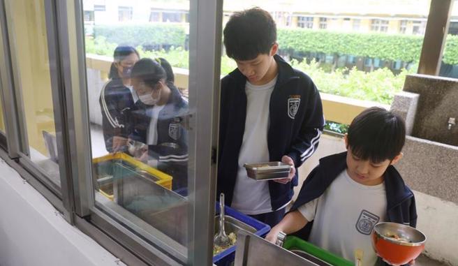国中学生正在享用营养午餐。（本报资料照）