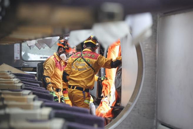 想定模擬飛機失事迫降於花蓮車站，造成行駛中列車翻覆，特搜人員馳援，採破壞列車車廂、機體方式，救出受困人員、後送救治。（記者黃迪明攝）