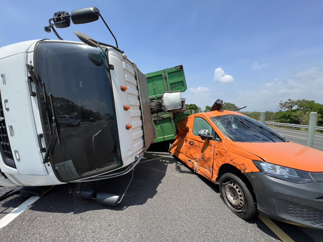 一輛自用大貨車行經338.9公里處時，左前輪突然「砰」一聲爆胎，當場失控衝撞中線車道的自小客車，兩車如同保齡球般猛烈掃向內側護欄，現場零件噴飛、車體扭曲變形，驚悚畫面曝光後令人捏把冷汗。（圖警方提供／簡銘柱翻攝）