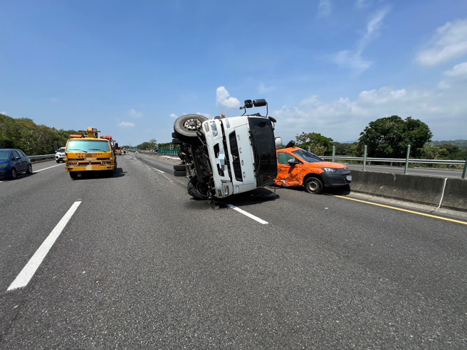一輛自用大貨車行經338.9公里處時，左前輪突然「砰」一聲爆胎，當場失控衝撞中線車道的自小客車，兩車如同保齡球般猛烈掃向內側護欄，現場零件噴飛、車體扭曲變形，驚悚畫面曝光後令人捏把冷汗。（圖警方提供／簡銘柱翻攝）