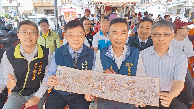 台南市文化局长林韦旭（右起）、台湾府城隍庙主委郭荣哲、台南市民政局长姜淋煌与中西区长蔡佳甫一起展示有漫画风的鸟瞰视角路关图。（程炳璋摄）