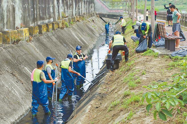 嘉义县水利处26日在民雄乡金兴村举行「全民清沟总动员」，村民穿着青蛙装走进沟渠，清垃圾、挖烂泥。（吕妍庭摄）
