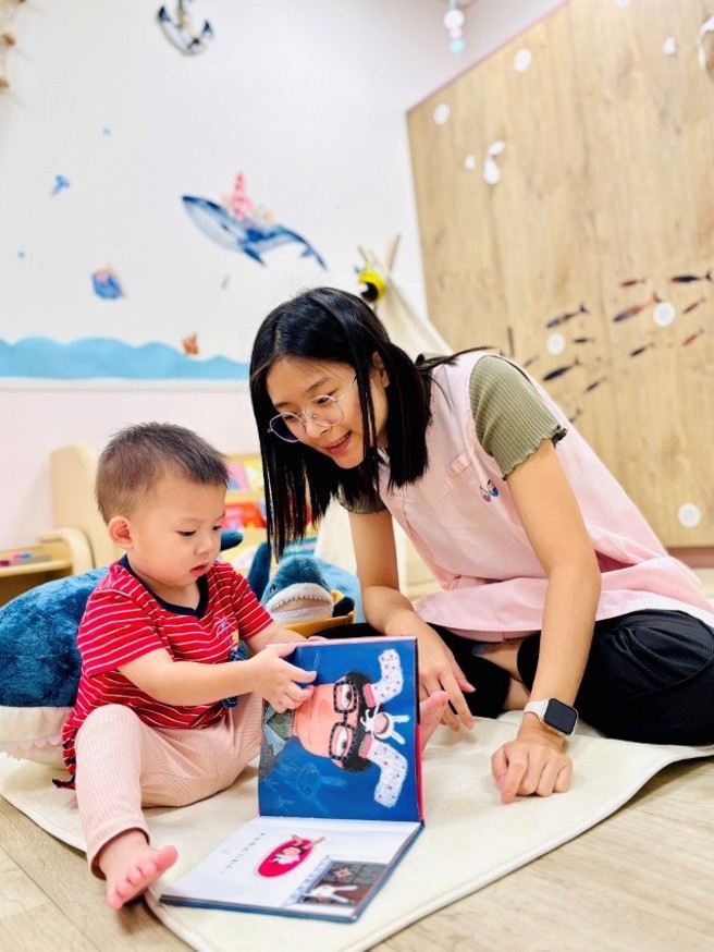 托育人員溫柔陪伴幼兒閱讀，打造安心、有愛的托育時光。(圖/桃園市政府婦幼發展局提供)