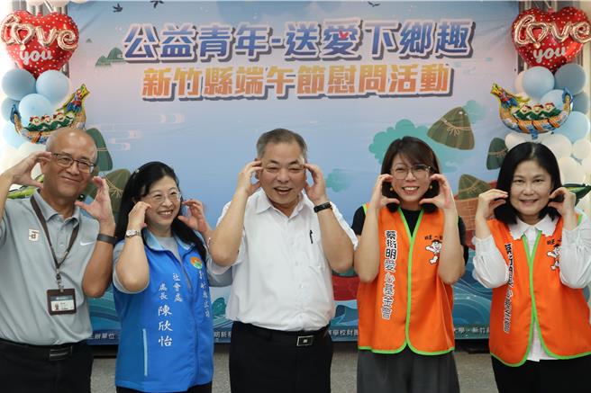 蔡衍明愛心基金會14日到新竹縣端午送愛下鄉，基金會執行長蔡紹云（右二）、新竹縣副縣長陳見賢（中）一起擺出可愛的愛心姿勢，盼受助家庭感受社會的溫暖與陪伴。（邱立雅攝）