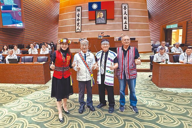 无党籍宜兰县议员孙汤玉惠（左一）与国民党议员游吉祥（右二）、沈志弘（右一）14日在议会总质询时，为代理县长林茂盛（左二）穿戴上原民服饰。（李忠一摄）