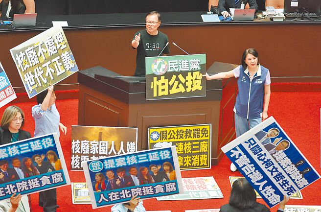 立院20日院会处理民眾党团所提「核三延役公投」案，蓝白联手表决通过，白委张启楷（中上）上台发言时，绿委群起拿标语抗议；蓝委王鸿薇（中右）则拿着「民进党怕公投」标语挺张。（姚志平摄）