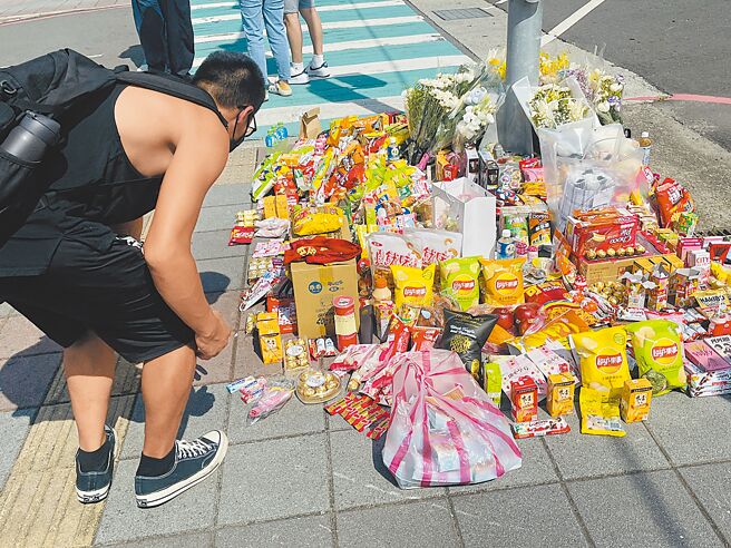 新北市三峡区国成街、国光街口19日下午4时许发生严重车祸，酿成3死12伤。民眾20日自发在现场放置鲜花、饮料、零食等追思物品。（李育嫺摄）
