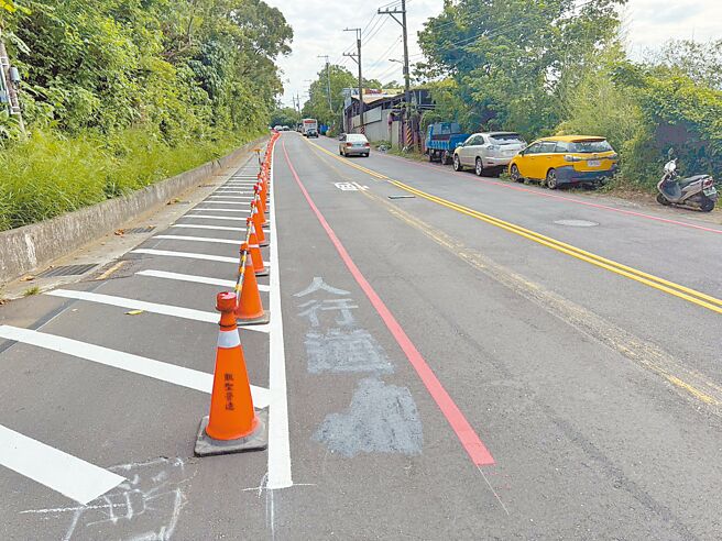 新北市淡水中山北路三段出现「夹缝人行道」，引发民眾质疑，淡水区公所19日已紧急修正，并加设微型钢护栏与警示灯。（淡水区公所提供／张铠乙新北传真）