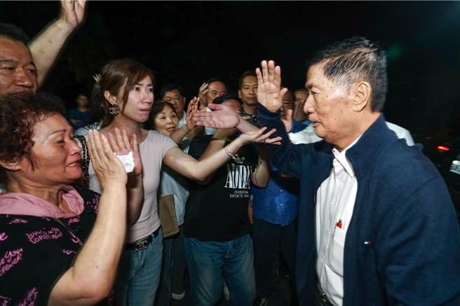 國民黨宜蘭縣黨部主委林明昌（右一）因涉幽靈連署遭檢調約談，22日凌晨0時許，他從調查站移送地檢署複訊，聲援的支持者與議員高喊「清白無罪」，林明昌則回應「司法會還我清白」。經複訊後檢方諭知林明昌80萬元交保。（李忠一攝）