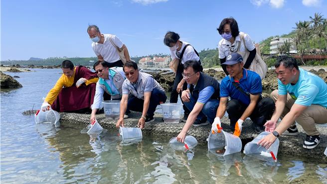 中华大悲法藏佛教会住持龙德严净仁波切（左一）、农业部次长黄昭钦（左二）与台东县政府农业处副处长黄奇明（左三）等人共同放流抱卵龙虾。（萧嘉蕙摄）