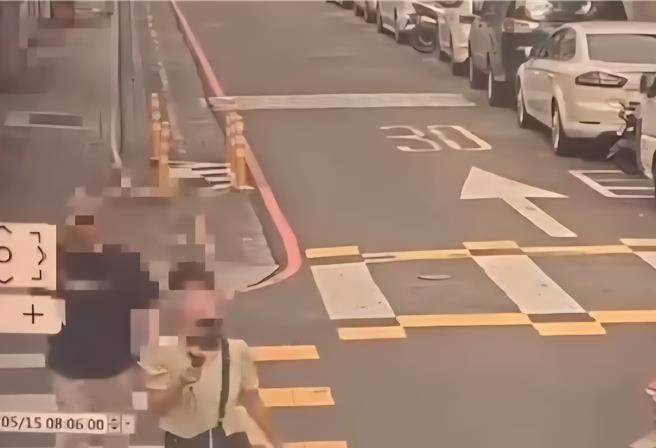 陆配边走边拍摄国小学童。（翻摄画面）