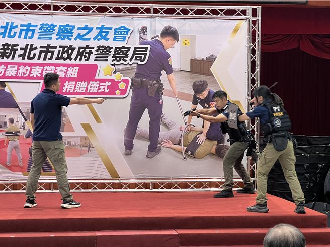 新北市警察局教官示范新型防暴约束带使用方式。（王扬杰摄）